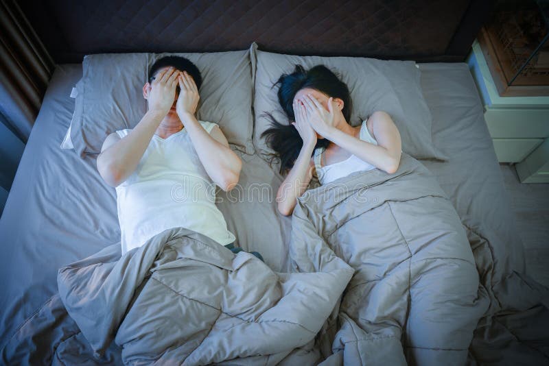 Shy Asian Couple Sleeping on Bed at Night Stock Image