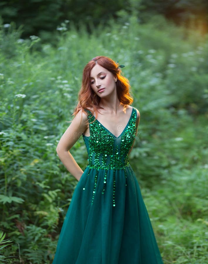 Red Hair Charming Woman is Lying on the Grass in a Wonderful Emerald ...