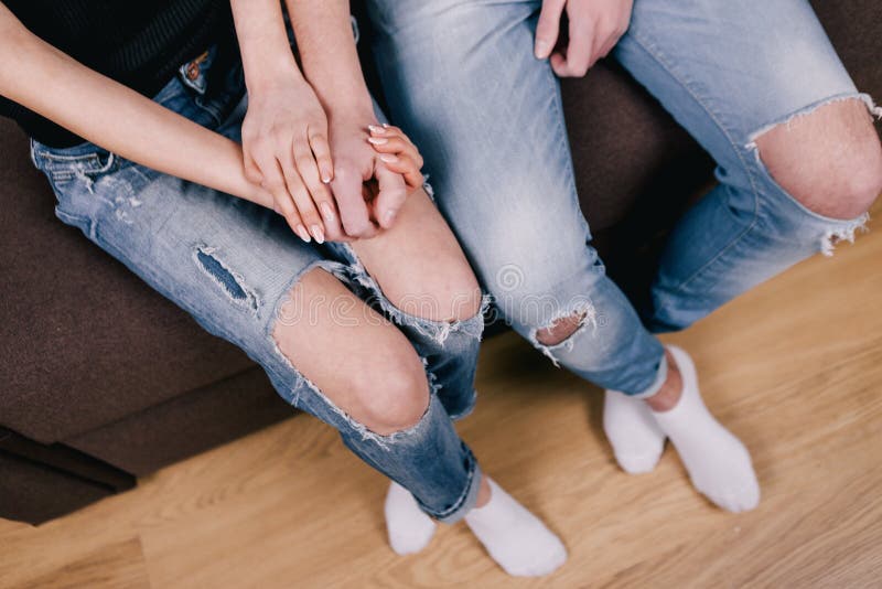 Shy lovers sitting together on brown bed