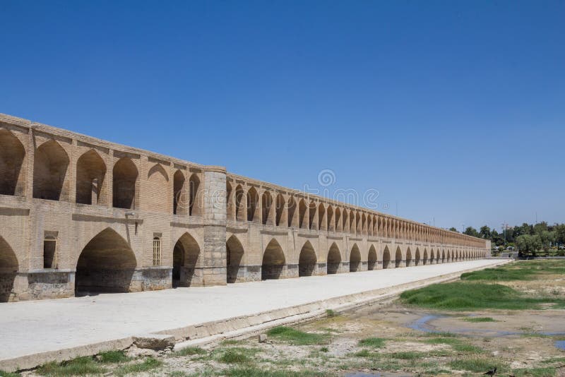 Si o Seh Pol bridge on the afternoon in Isfahan, Iran. Also known as Allahverdi Khan Bridge, or 33 arches bridge, it is a major landmark of the city and a symbol of the Persian Safavid Architecture Picture of the iconic bridge of Si o Seh, in the center of Isfahan. The river Zayandeh is dry due to the season. The Allahverdi Khan Bridge, it is the largest of the eleven historical bridges on the Za. Si o Seh Pol bridge on the afternoon in Isfahan, Iran. Also known as Allahverdi Khan Bridge, or 33 arches bridge, it is a major landmark of the city and a symbol of the Persian Safavid Architecture Picture of the iconic bridge of Si o Seh, in the center of Isfahan. The river Zayandeh is dry due to the season. The Allahverdi Khan Bridge, it is the largest of the eleven historical bridges on the Za