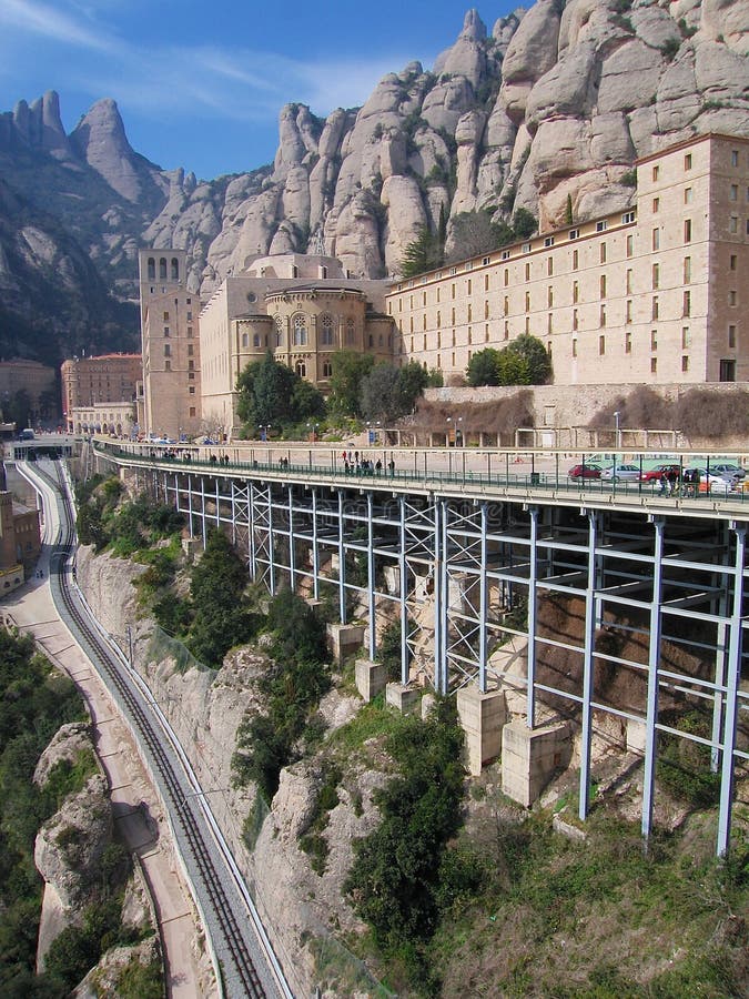 Si può vedere il famoso monastero benedettino di Montserrat e la linea ferroviaria di Montserrat, Spagna fotografia stock Si può vedere il famoso monastero benedettino di Montserrat e la linea ferroviaria di Montserrat, Spagna fotografia stock