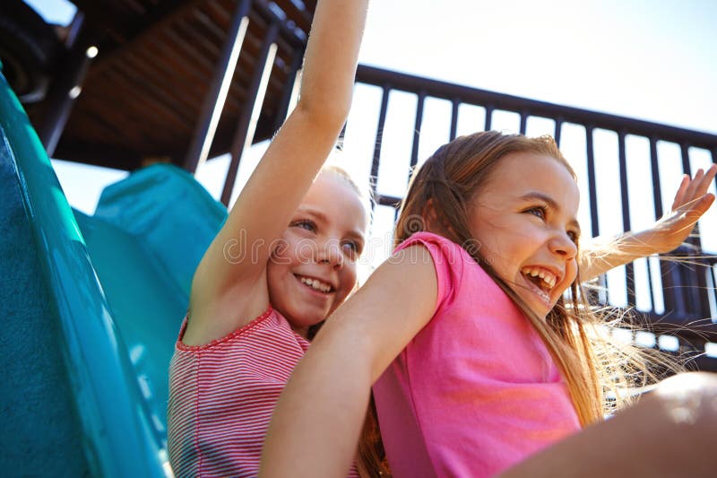 Sibling Fun. Two Little Girls on a Slide at the Play Park. Stock Image ...