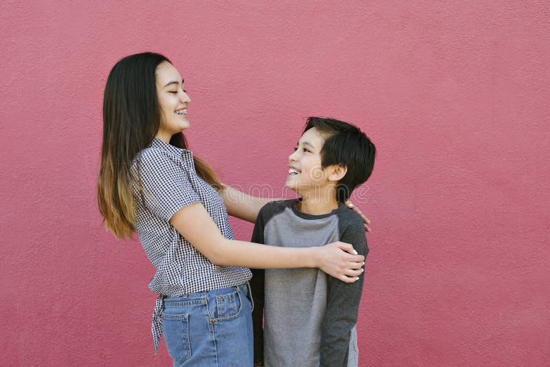 View of a brother and sister embracing and having fun on a sunny day. View of a brother and sister embracing and having fun on a sunny day