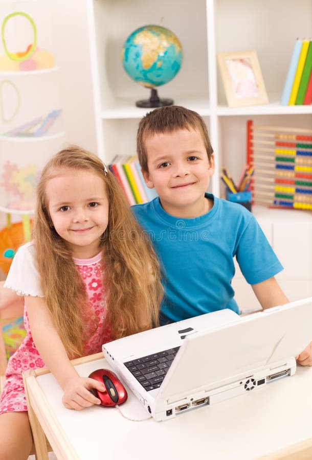 Little boy and girl with laptop computer in their room smiling to the camera. Little boy and girl with laptop computer in their room smiling to the camera