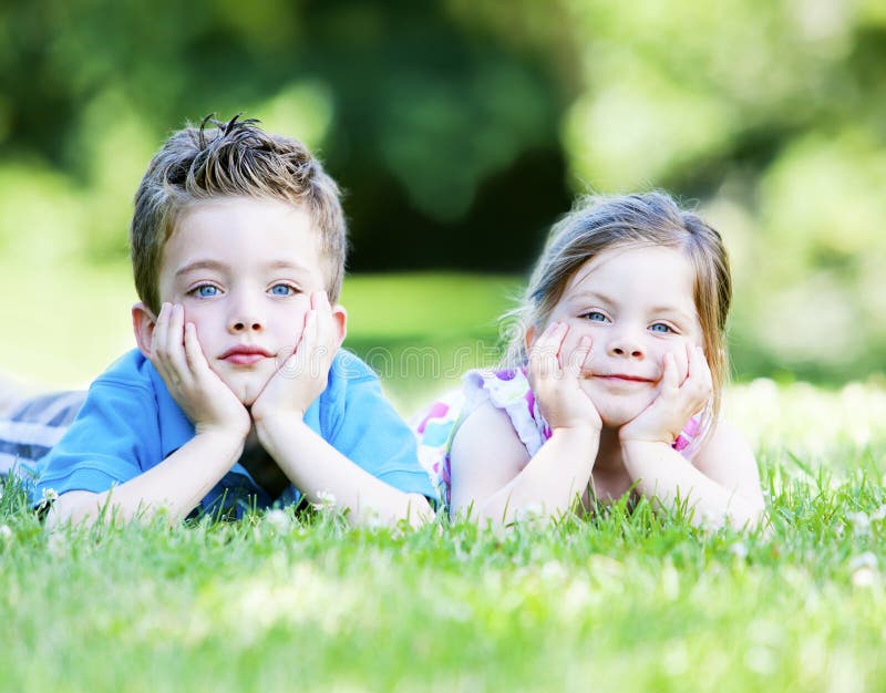Siblings Laying in the Grass Stock Photo - Image of pose, field: 22241304