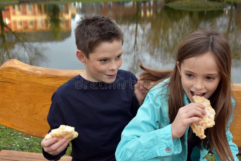 Siblings sharing a piece of pastry royalty free stock photos Siblings sharing a piece of pastry royalty free stock photos