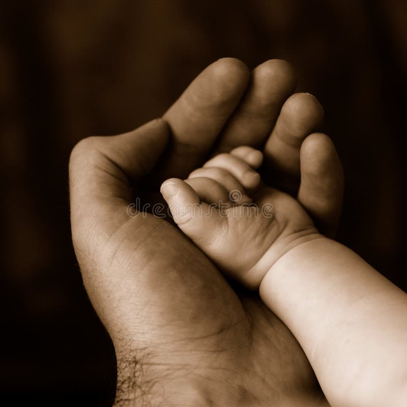 Sepia of father holding baby's hand. Sepia of father holding baby's hand.