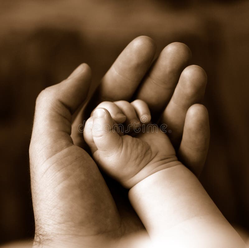 Sepia of father holding hand of sleeping baby. Sepia of father holding hand of sleeping baby.