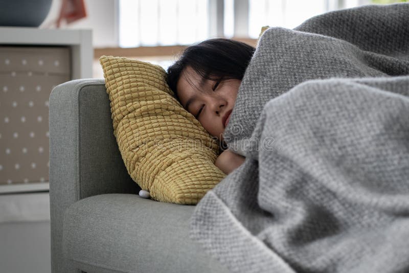 Sick Asian Woman Sleeping On Sofa Under Blanket At Home Recovering