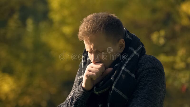 Sick male in scarf coughing in park, caught cold, pneumonia risk, infection stock image Sick male in scarf coughing in park, caught cold, pneumonia risk, infection stock image