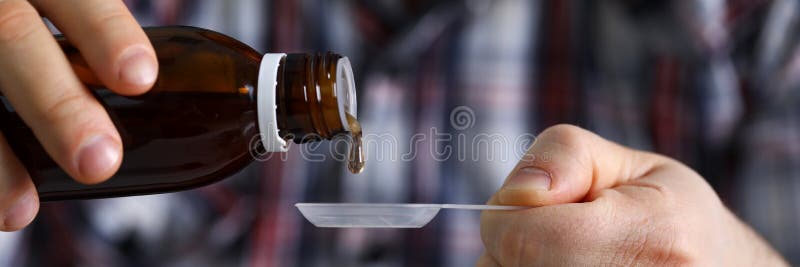 Sick man holding in hands vial with syrup close-up