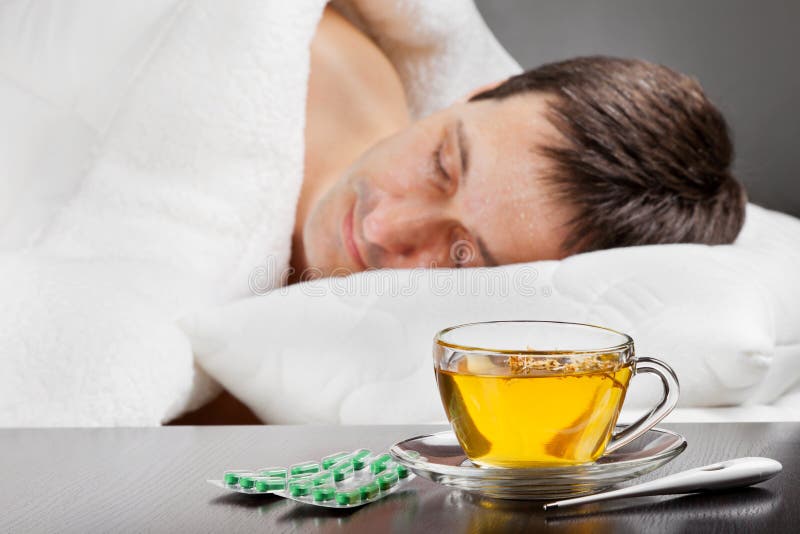 Sick man lying in bed with fever