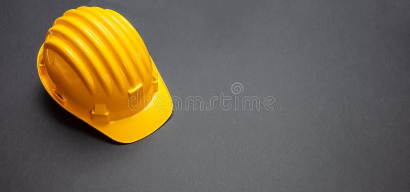 Sicurezza di progetto di costruzione, casco giallo sul fondo nero di colore