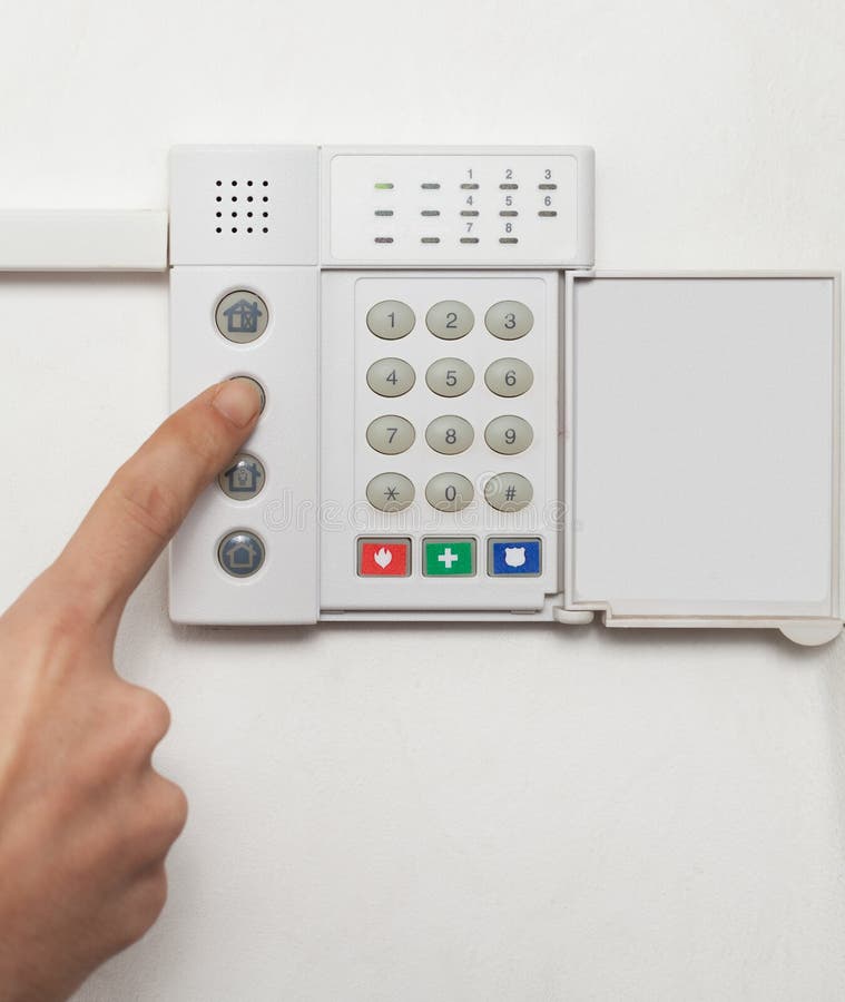 Setting up a security alarm on a white wall. Setting up a security alarm on a white wall