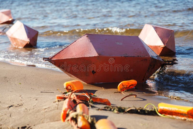 Sicurezza sull'acqua Parecchie grandi boe arancio si trovano orizzontalmente sulla Banca sabbiosa del fiume fotografia stock Sicurezza sull'acqua Parecchie grandi boe arancio si trovano orizzontalmente sulla Banca sabbiosa del fiume fotografia stock
