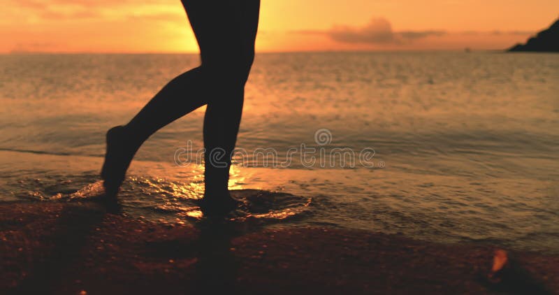 Sida silhuette- kvinnbenen går solnedgång