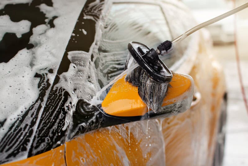 Side Mirror of Bright Red Car Washed in Self Serve Carwash, Water