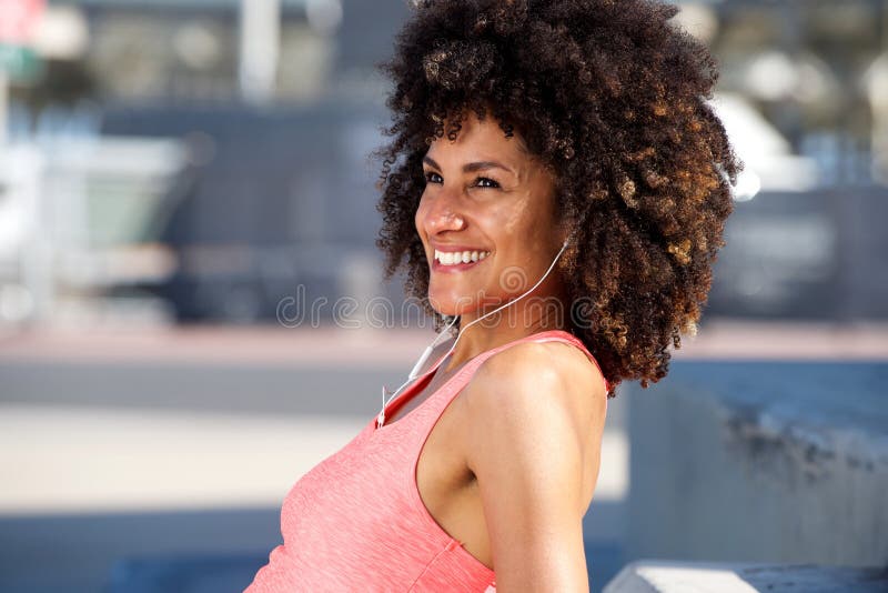 Side portrait of beautiful sporty woman laughing and listening to music royalty free stock photo Side portrait of beautiful sporty woman laughing and listening to music royalty free stock photo