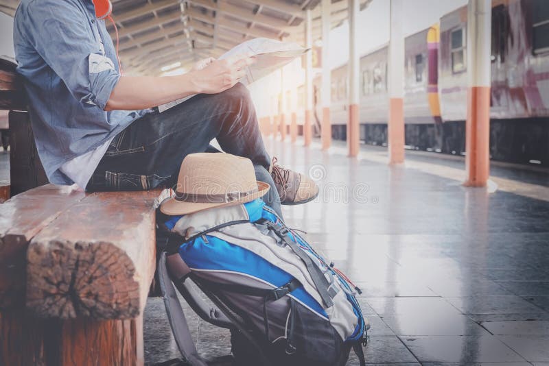 Side portrait of a young man traveler sitting with map choose w stock photo Side portrait of a young man traveler sitting with map choose w stock photo