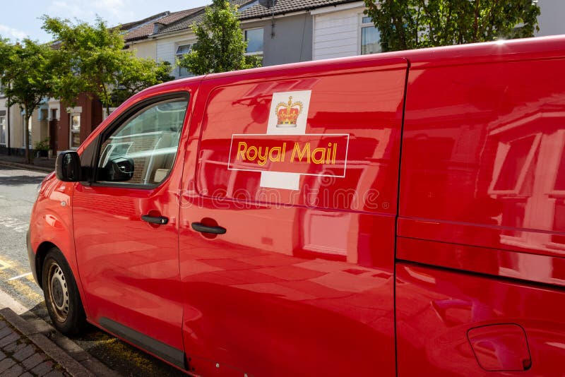 The Side of a Red Royal Mail Van with Houses Reflecting in the