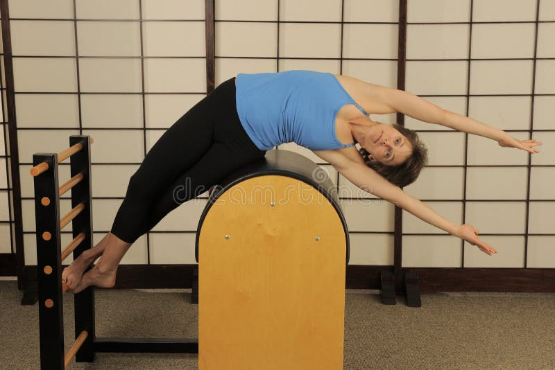 Pilates trainer exercises on a pilates barrel. Body training, perfect body  shape and posture correction opporno motor apparatus. Copy space Stock  Photo - Alamy