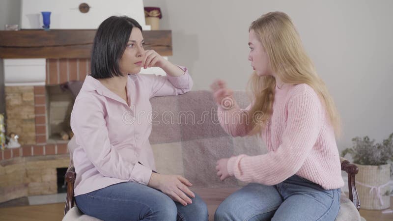 Side view of brunette Caucasian woman listening carefully to her adult daughter talking emotionally. Teen daughter