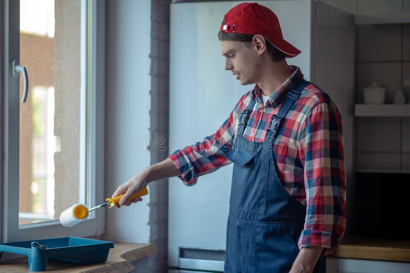 Skilled Young Repairman Involved in Painting Work Stock Photo Image