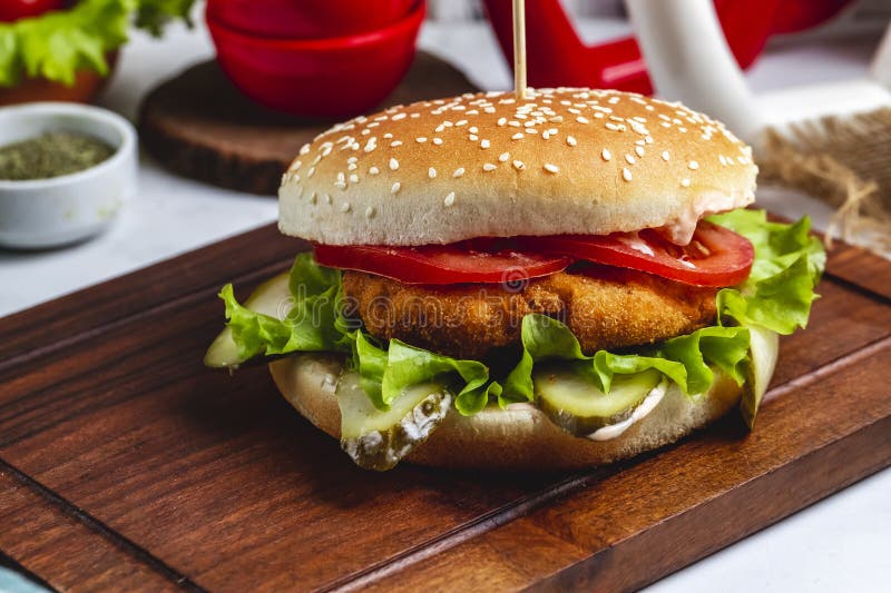 Side view chicken burger with sliced ​​tomato and lettuce on the board s