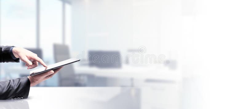Side view and close up of businessman hand using pad screen on blurry white office background with mock up place. Technology and stock images