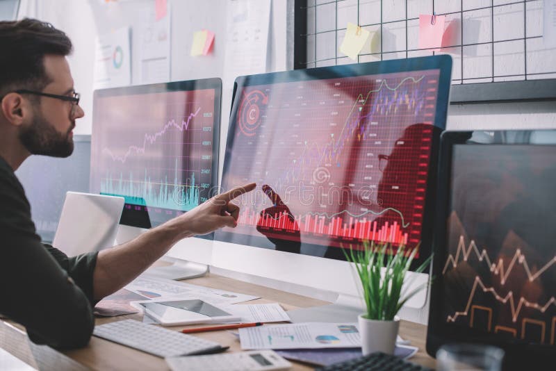 Side view of data analyst pointing with finger at charts on computer monitor while testing protection royalty free stock photography