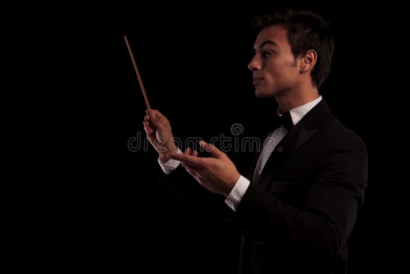 Side view of an elegant music conductor holding a batton