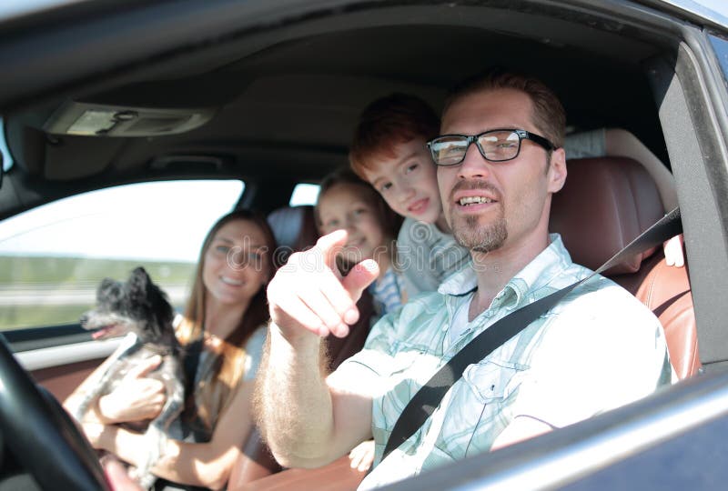 Side view.happy father driving a family car .the concept of freedom and travel