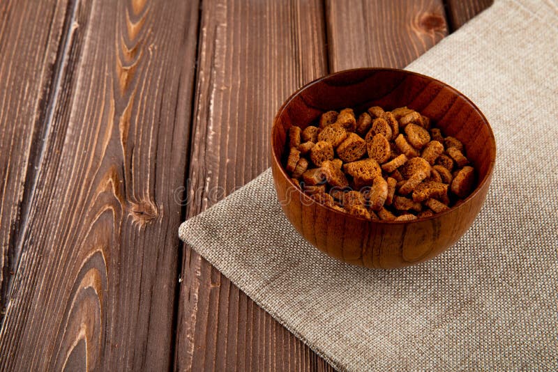 Side view hard chuck on the right in bowl with copy space on wooden background stock photos