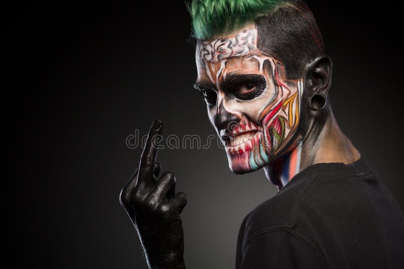Side view if a man with colored skull makeup showing long finger. royalty free stock images Side view if a man with colored skull makeup showing long finger. royalty free stock images