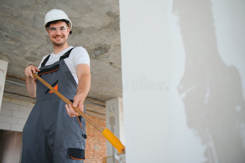Side view of painter man painting the wall, with paint roller royalty free stock photos