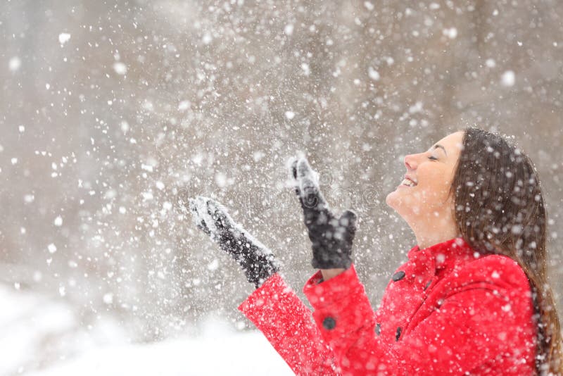 Happy woman playing with the snow on winter holiday