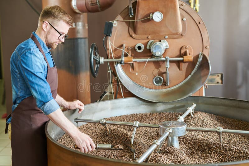 Handsome Coffee Roaster standing by Machine stock photos