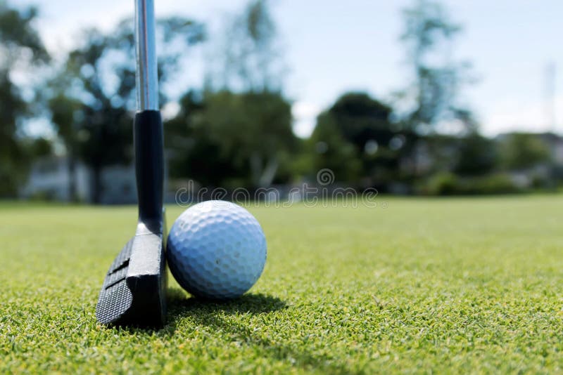 Side view of a putter and a white golf ball