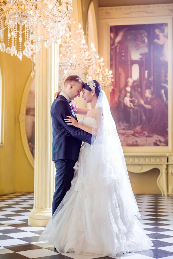 Side view of romantic wedding couple standing in church