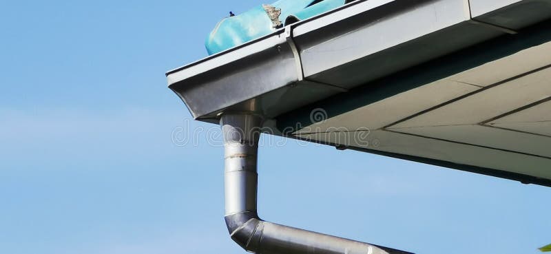 Side view. roof corner with gutter, background is cloudless sky