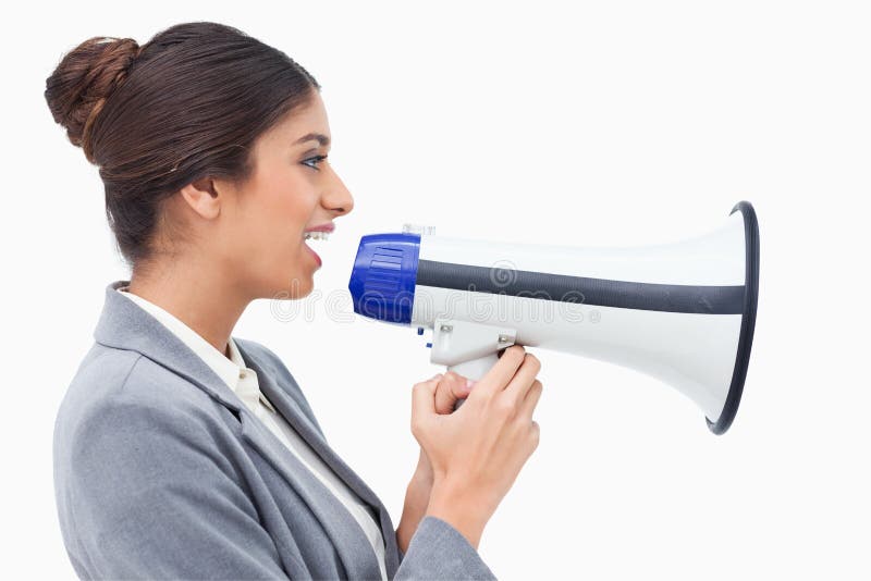 Side view of saleswoman using megaphone against a white background