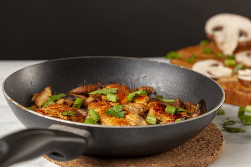 Side view selective focus image of sauteed roasted chicken breasts in a non stick frying pan royalty free stock image