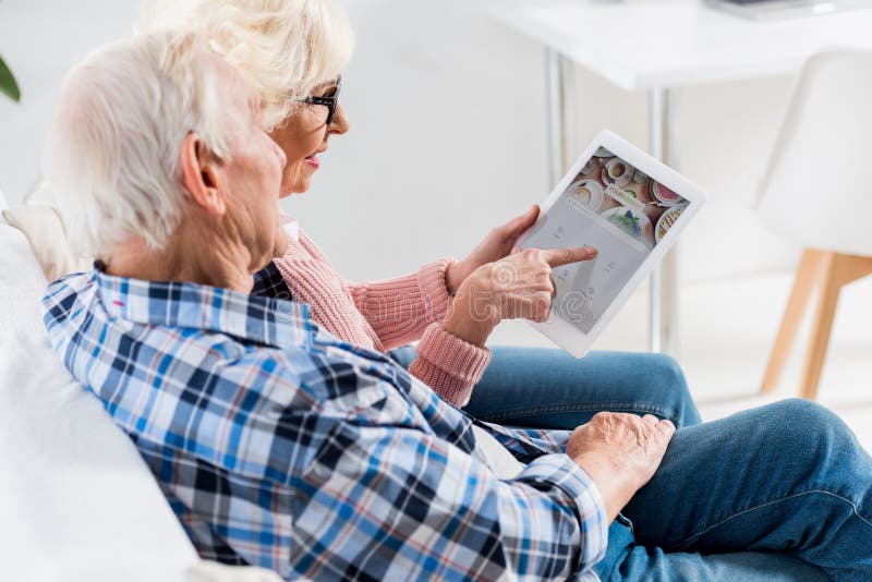 side view of senior couple using digital tablet with foursquare