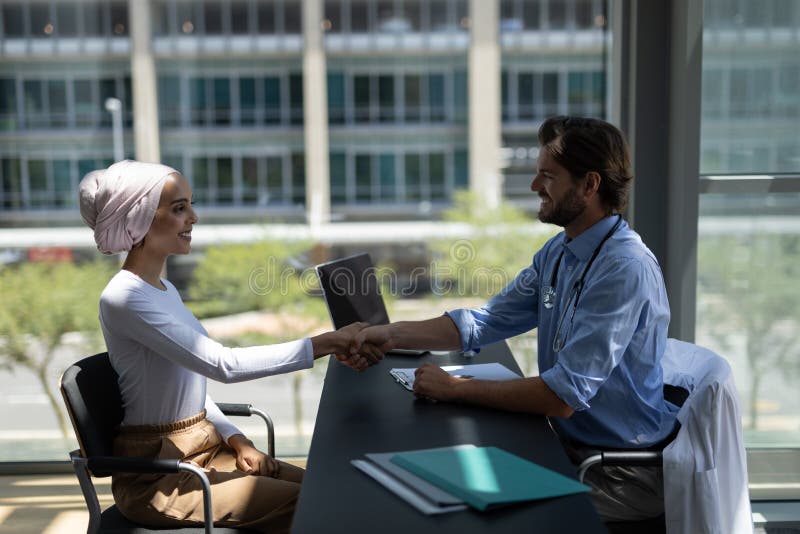 Disabled mixed-race woman shaking hands with Caucasian male doctor stock photo Disabled mixed-race woman shaking hands with Caucasian male doctor stock photo