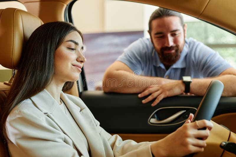 Woman behind Wheel Testing Car with Boyfriend at Dealership Center royalty free stock images