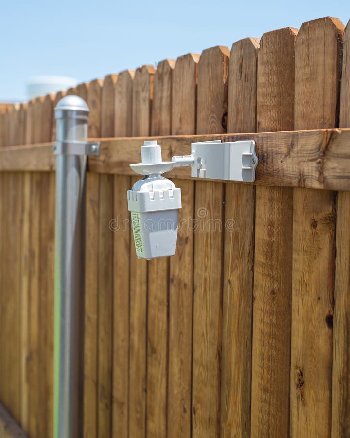 Side view wireless rain and freeze sensor auto shuts off irrigation sprinkler system when raining or freezing, rainfall and cold stock photo