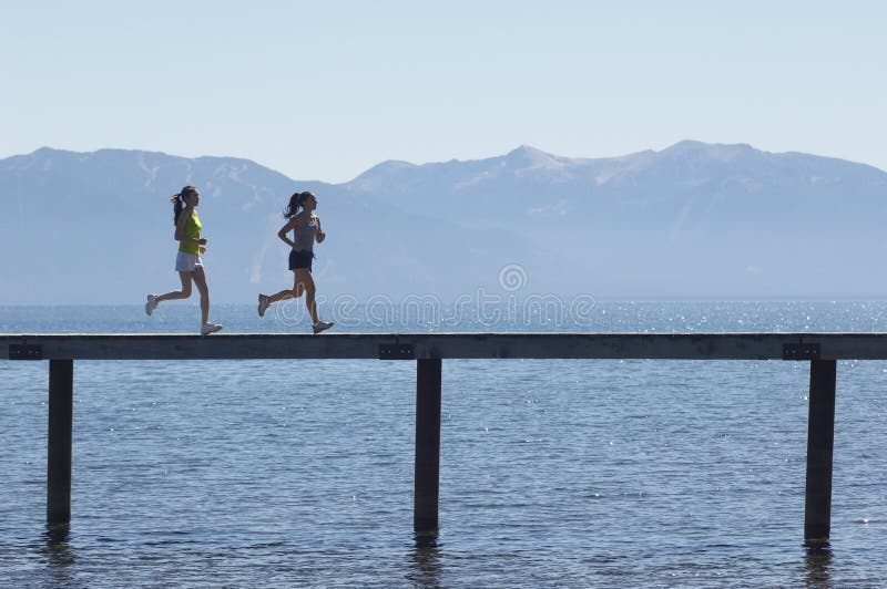 Side View Of Women Running Along Pier