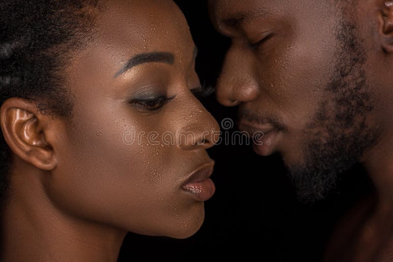 side view of young african american couple with water drops on faces posing