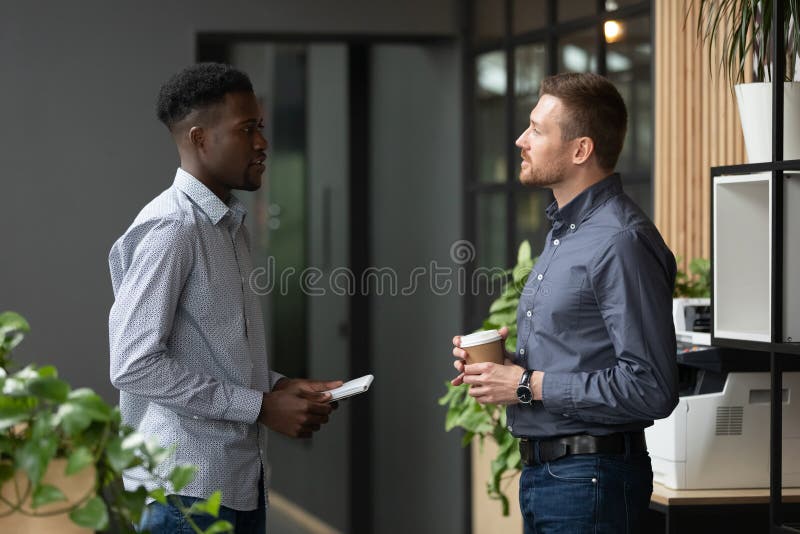 Young african american male intern consulting with boss.