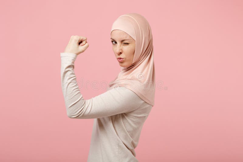Side view of young arabian muslim woman in hijab light clothes posing isolated on pink wall background. People religious royalty free stock images